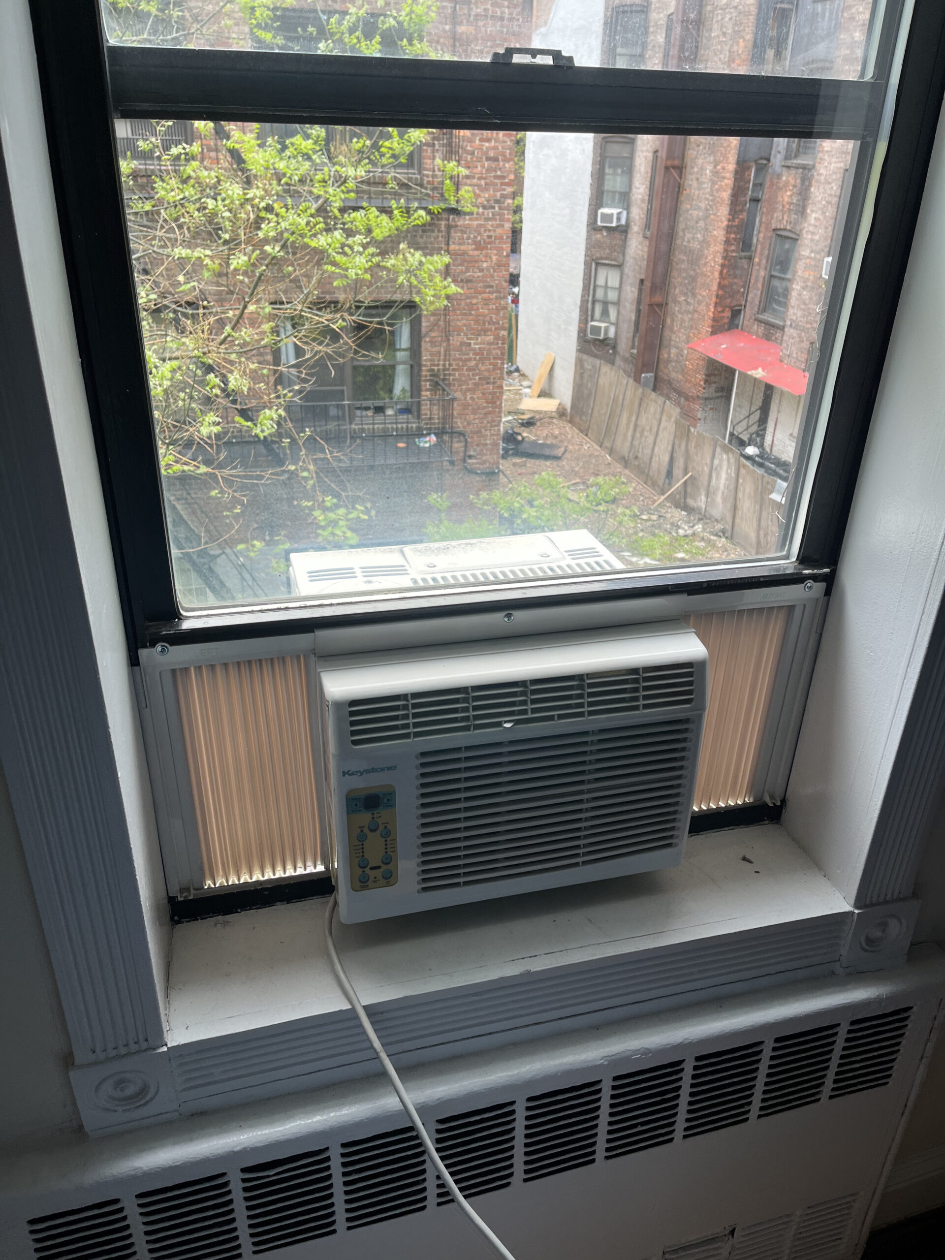 Technician removing old window AC unit