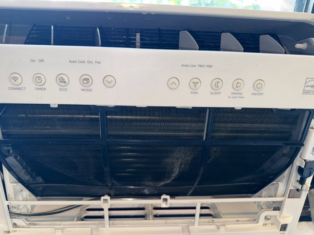 dirty window AC unit with mold buildup and poor drainage