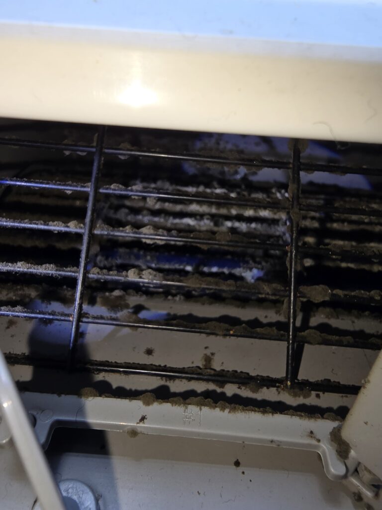 Dirty Midea window air conditioner opened for deep cleaning in NYC apartment